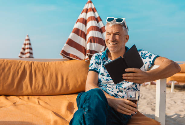 Handsome gay male senior adult man enjoying down time on a sunny summery day on a beach holiday in the Netherlands