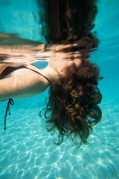 Side view of Human hair floating in the water , girl resting and swimming in the water
