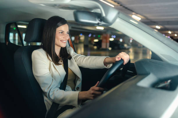 istock Beautiful young woman driving a car 2152810397