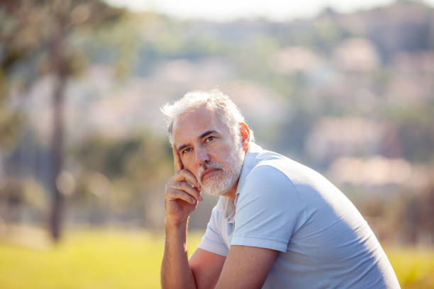 Pensive middle age man portrait outdoors looking at view