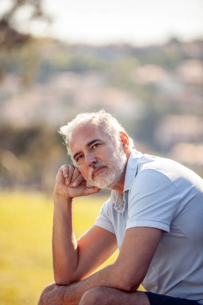 Pensive middle age man portrait outdoors looking at view