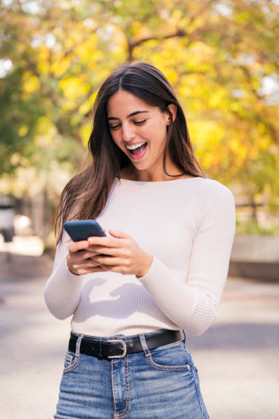 istock caucasian woman laughing happy using mobile phone 2152815211