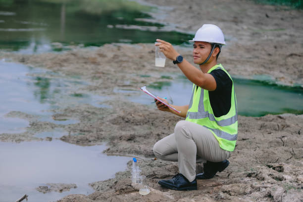 istock Environment Issue concept. Team of Scientists in protective suits and masks took a sample of water for analysis. Environment Issue concept 2152815684