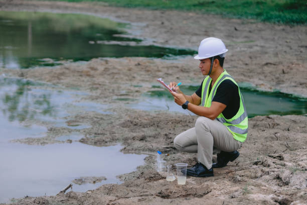 istock Environment Issue concept. Team of Scientists in protective suits and masks took a sample of water for analysis. Environment Issue concept 2152815695