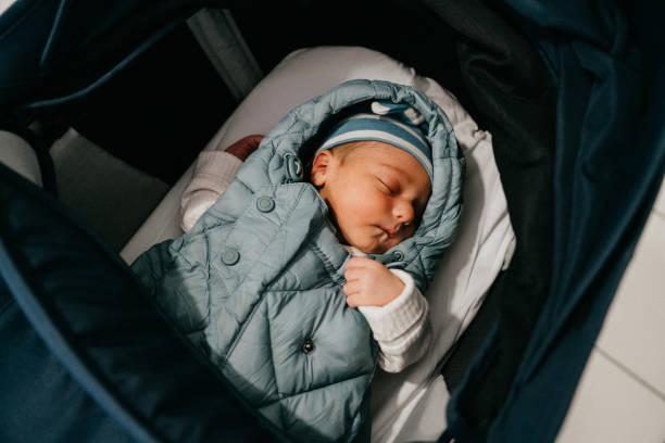 A newborn baby is sleeping in his stroller