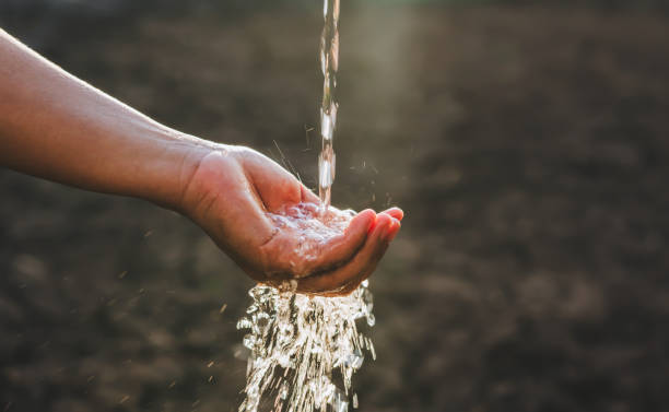 istock hand is holding a stream of water 2152823039
