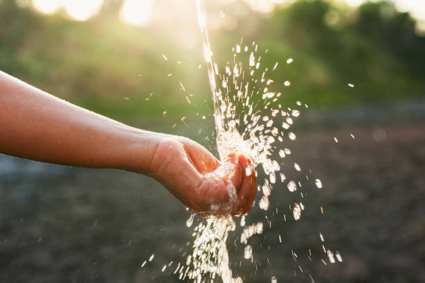 istock hand is holding a stream of water 2152823046