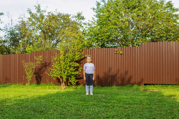 istock Child Girl Standing Alone in Garden 2152823280