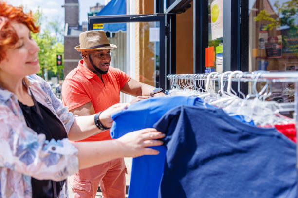 istock Thrift shopping date: multiracial couple enjoys a date sifting through selecting clothes in Madison, NJ. 2152826611