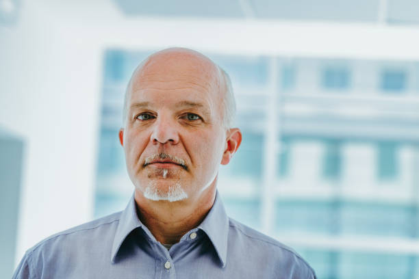 istock Older man stands contemplatively before large window 2152828112
