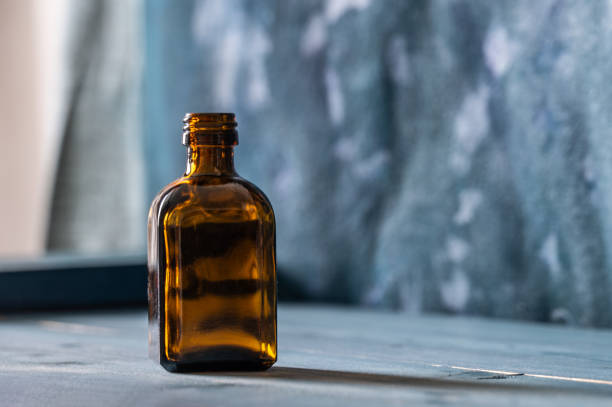 This is a photograph of glass yellow bottle indoors with natural sunlight at home.