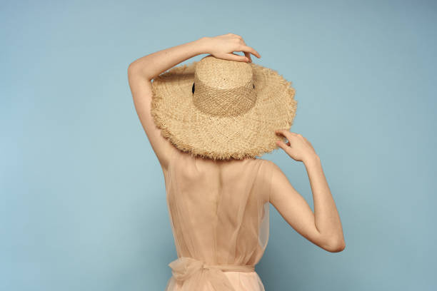 istock Woman in hat with naked back on blue background model back view 2152835280