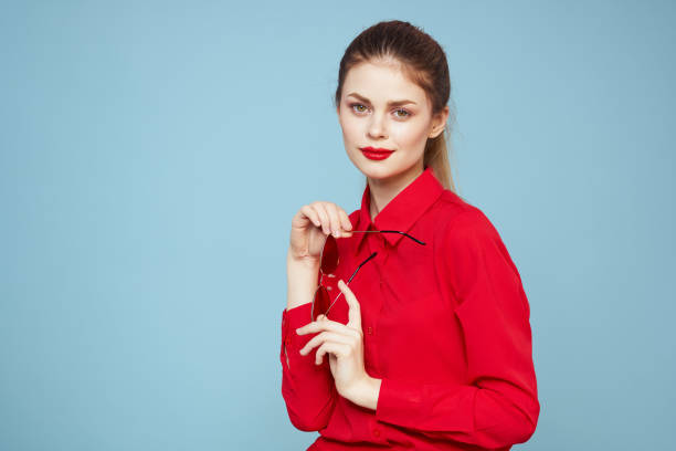 istock Woman with dark glasses red lips charm shirt studio blue background 2152835578