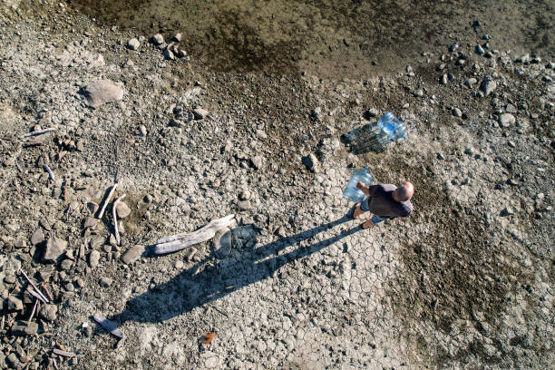 istock Man with water bottles on lakeshore 2152835787