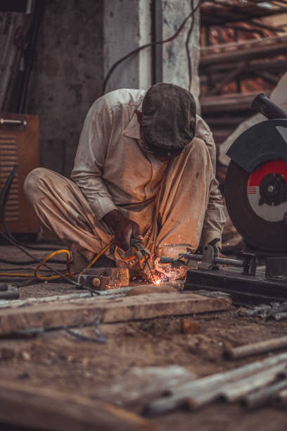istock Welder welding metal with sparks and flames in his workshop 2152838533