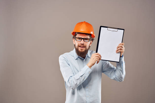 istock A man in a shirt with an orange hard hat engineer work documents rendering services 2152839600