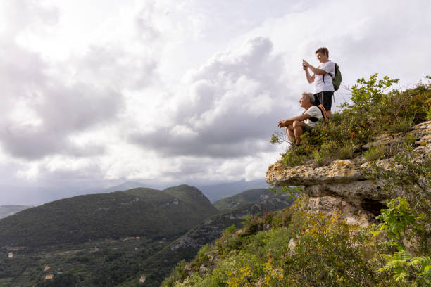 istock Father and son pause on hilltop and take photo 2152844663