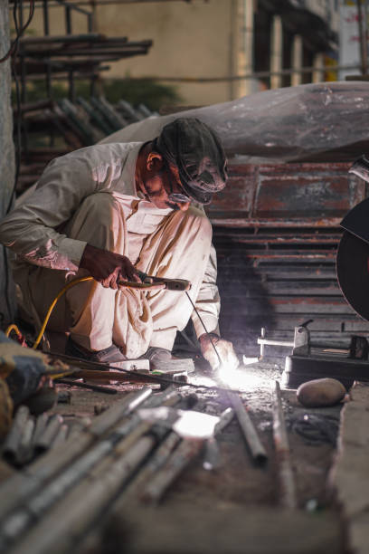 istock Welder welding metal with flash and sparks in his workshop 2152844885