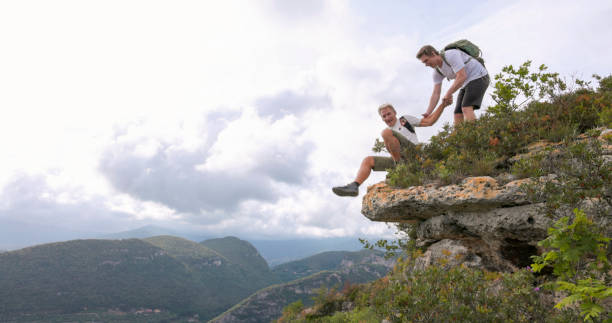 istock Adult son helps father on hilltop 2152846072