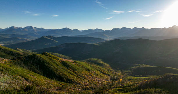Elevated view of forest, valley and mountains at sunset
