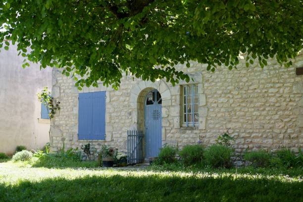 Facade of stone house with blue shutters in a small tourist village