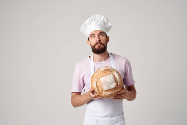 istock bearded man in a white apron with bread in the hands of a baker 2152847906