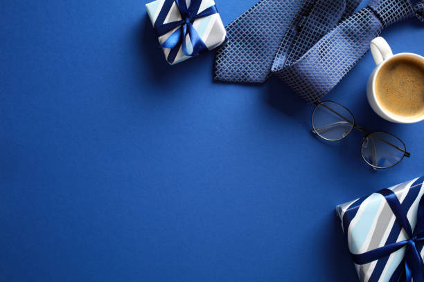 istock Fat lay composition with gift boxes, coffee cup, and eyeglasses on a blue background. Fathers Day concept. 2152849345