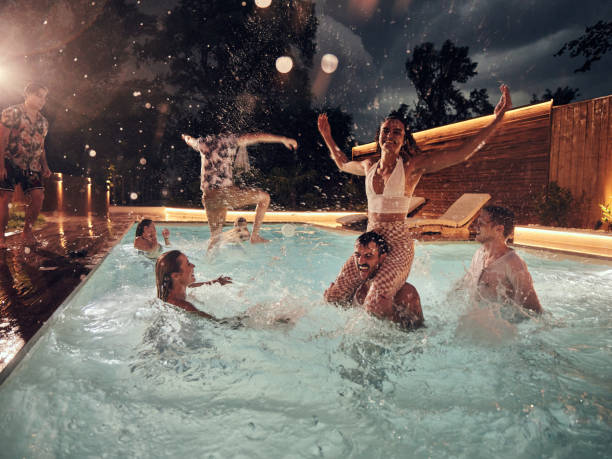 istock Carefree friends having fun in the pool at night. 2152850119