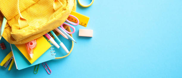 istock Vibrant school essentials spilling from a yellow backpack on a blue backdrop, perfect for educational themes and back-to-school campaigns 2152850564