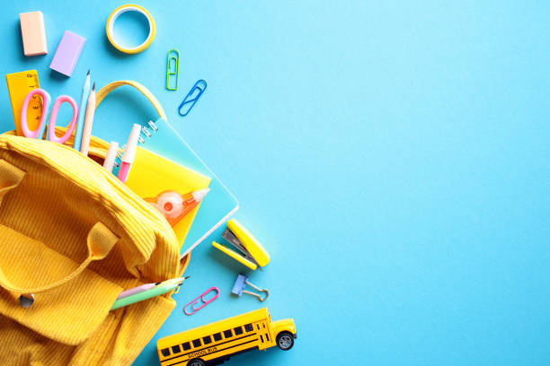 istock Vibrant School Supplies Flat Lay: A cheerful composition featuring a yellow backpack overflowing with school essentials, including colorful pencils, erasers, clips, and a miniature school bus 2152850927