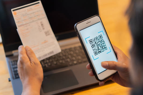 istock Male hand holding a mobile phone to scan the QR code for the bill through the app. 2152852553
