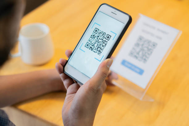 istock Selective focus of man's hand scanning QR code through mobile phone at cafe table. 2152852565