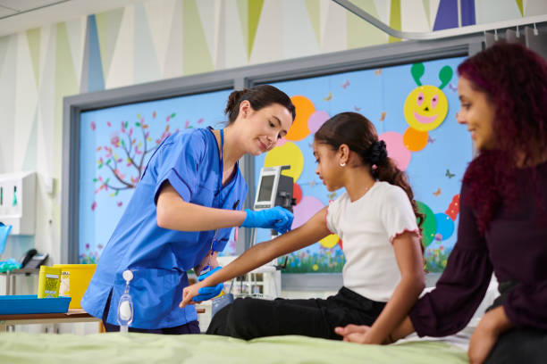 A young girl rests in a hospital bed, comforted by a nurse who is holding her hand, illustrating care, compassion, and support in a medical setting.