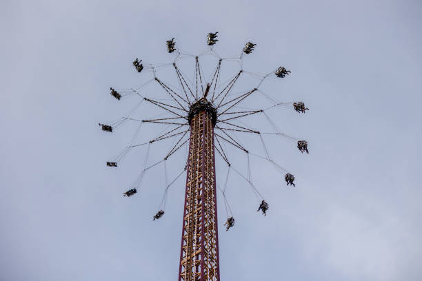 High-altitude swing carousel ride spinning at the Beer Fest amusement park in Munich, Germany, with decorative lights in the foreground.