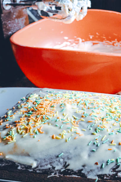 home baked cake with icing and sprinkles and whipped cream