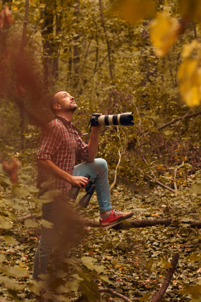 istock Man using binoculars and camera for bird and animal watching in nature. 2152858780