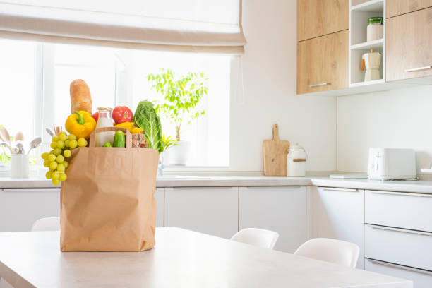 istock Paper bag full of food on table in modern kitchen interior with copy space 2152860084