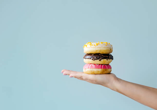 istock Hand holding three donuts, baked goods with staple food ingredients 2152862952
