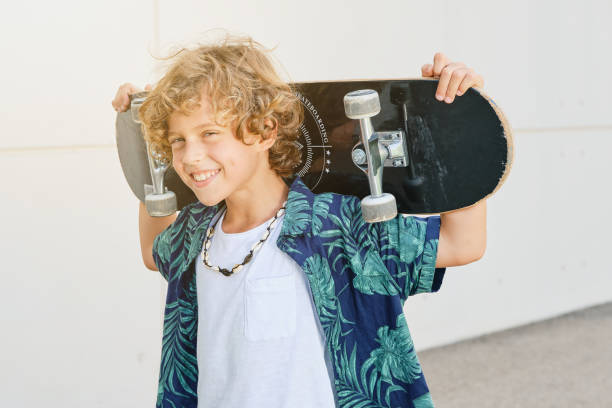 istock Cheerful boy with skateboard on neck 2152863495