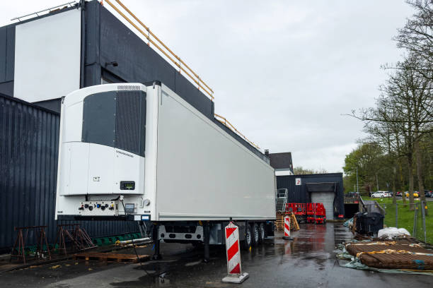istock White refrigerated semi-trailer near a warehouse. 2152863750