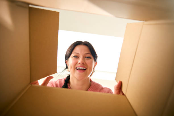 istock View Looking Up At Young Excited Woman Opening Cardboard Box 2152865244