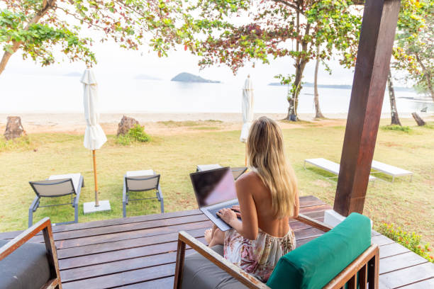 istock Woman Working on Laptop with Scenic Beach View 2152867126