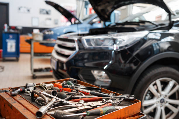 Mechanic tools in tray near car under repair