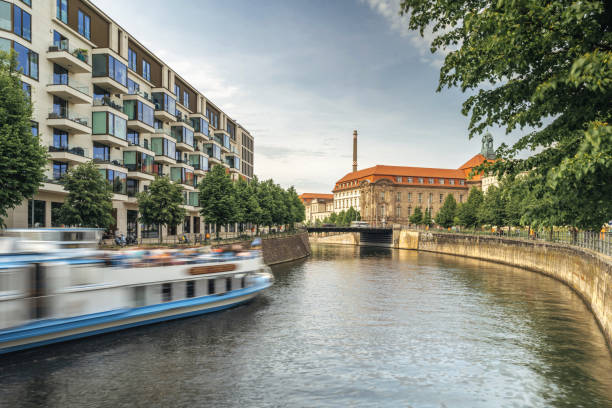 modern residential houses at river in central berlin - motion blurred tour boat