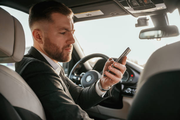 istock Man in black suit is sitting in the car, driving 2152873941