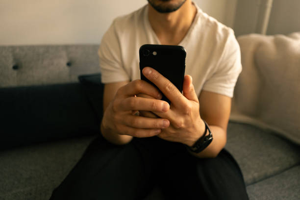 istock Close-up young man using smartphone at home 2152874179