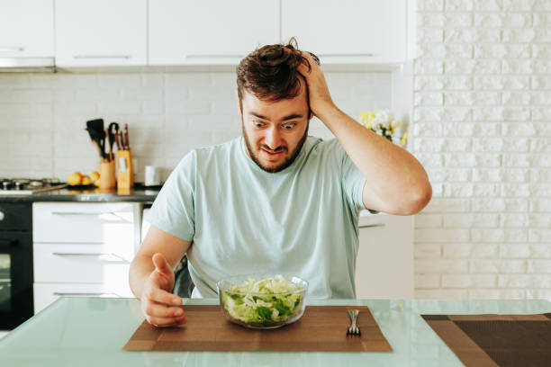 istock A panicky look at a green salad in a young man on a diet. 2152874521