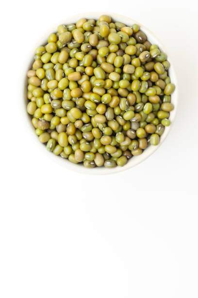 istock Uncooked, green mung beans in bowl on white background. Space for a text 2152874709