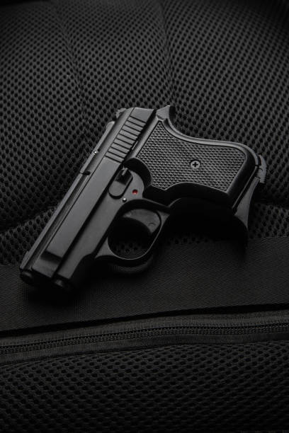 istock A small semi-automatic pistol on a dark background. Weapons for concealed carry and self-defense. Short-barreled weapon. Ladies pistol. 2152879063