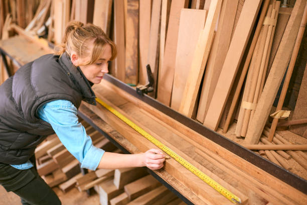 istock Female Carpenter Working In Woodwork Workshop Measuring Wood For Project 2152883353